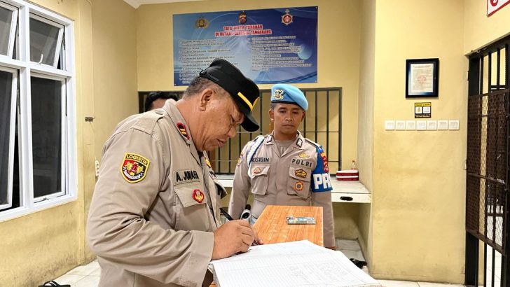 Iptu Ahmad Junaedi selaku Pawas melakukan pengecekkan buku mutasi jaga tahanan pada malam hari