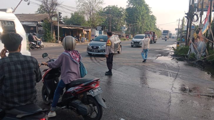 Anggota Bhabinkamtibmas Aipda Ikrar Dinata Polsek Balaraja melaksanakan Pengaturan lalu lintas untuk Melayani Masyarakat