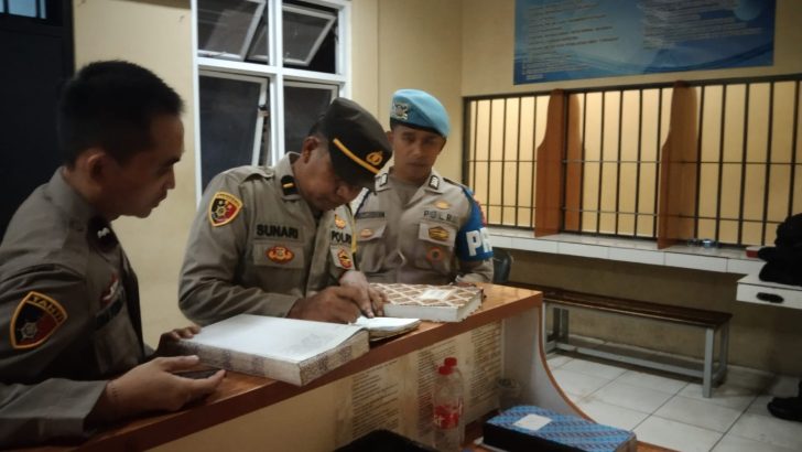 Wapawas Ipda Sunari mengecek buku mutasi kegiatan personel jaga tahanan pada malam hari