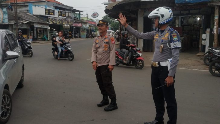 Pawas dan personil Polsek Rajeg dibantu dengan Personil Dishub melaksanakan pengaturan arus lalin diperempatan TL kukun guna memperlancar arus lalin