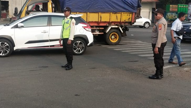 Personil Sat Pamobvi Polresta Tangerang melaksanakan pengaturan lalu lintas di perempatan lampu merah Cikupamas.