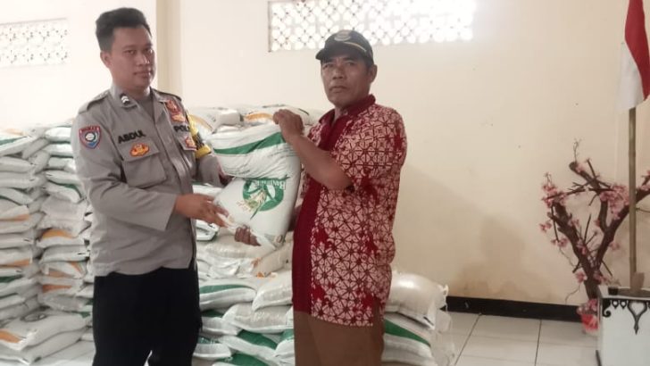 Bhabinkamtibmas desa daon memantau pendistribusian beras untuk warga di desa binaannya